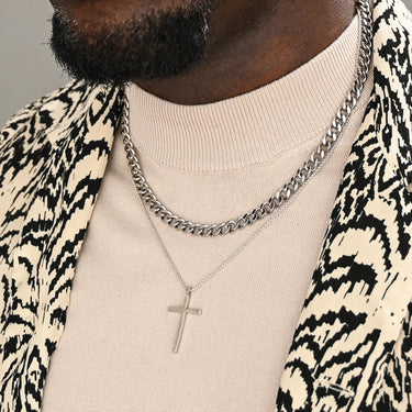 Starfish Project stainless steel linked curb chain necklace worn layered with a cross pendant on a man in a patterned blazer