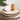 Kindred & Kin dishwashing soap bar shaped like a lemon slice and bamboo brush with sisal bristles on stack of plates.