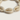 Kindred & Kin Bombchel adjustable bracelet featuring natural cream-colored cowrie shells on a hand-knotted cord