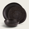 Kindred & Kin Exuberant stoneware dinnerware set featuring black plates and a bowl with hand-applied concentric lines.