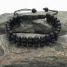 Starfish Project matte black agate double-strand rope beaded bracelet with adjustable pull closure on a stone surface