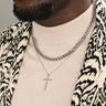 Starfish Project stainless steel linked curb chain necklace worn layered with a cross pendant on a man in a patterned blazer