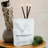 Bathorium Northern Sage Recovery mineral bath soak pouch on a wooden tray with sage and pine needles.