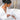 Bathorium Northern Sage Recovery bath soak held by a woman in a white robe over a steaming bathtub