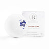 Bathorium Snooze Bath Bomb with dried flower petals, next to its white branded packaging.