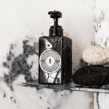 Kindred & Kin Castelbel Gentlemen's Club Patchouli & Sandalwood Hand & Body Wash in a dark bottle with water droplets.