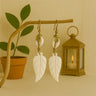 Kindred & Kin Amani Leaf Earrings with white cowrie shells and hand-carved bone leaf pendants.