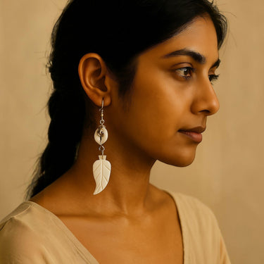 Kindred & Kin Amani Leaf Earrings featuring a cowrie shell and hand-carved bone leaf pendant. White.