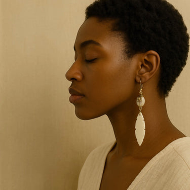Kindred & Kin Serenity Cowrie Earrings: white cowrie shell & carved bone leaf pendant with brass spiral detail.