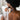 Kindred & Kin Bathorium Konjac and walnut shell exfoliating sponge creating a lather on a person's back in the shower.