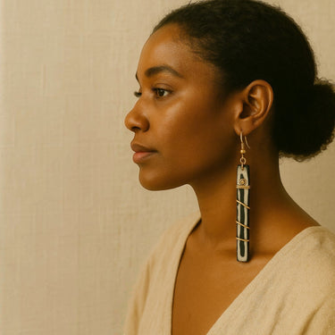 Kindred & Kin Nomad Lineage earrings: hand-carved bone with spiraled brass wire, black and white linear silhouette.