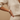 Kindred & Kin Bombchel adjustable cowrie shell bracelet on a wrist with a beige linen outfit