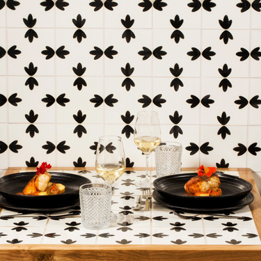 Kindred & Kin Exuberant stoneware dinnerware set with black plates featuring hand-applied concentric white lines.