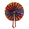 Kindred & Kin foldable fabric fan with abstract print in red, orange, purple, and green. Features leather-wrapped handles.