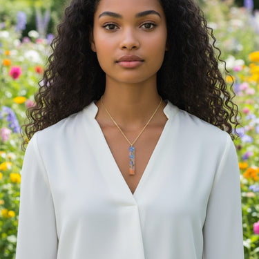 Kindred & Kin Forget Me Not Palito necklace with blue flowers preserved in resin and Palo Santo accents on a gold chain.