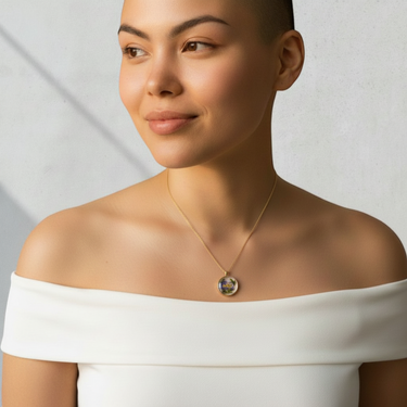 Kindred & Kin Full-Moon Larkspur necklace featuring a resin pendant with purple and white petals on a gold-plated chain