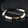 Kindred & Kin Vanguard lava bead bracelet featuring beige and black beads with bronze and blue emperor stone accents.